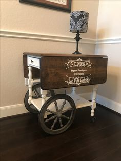 an old fashioned wooden cart sitting on top of a hard wood floor next to a wall