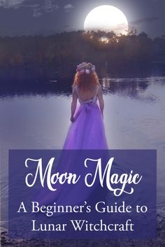 a woman in a purple dress standing on the edge of a lake with her back to the