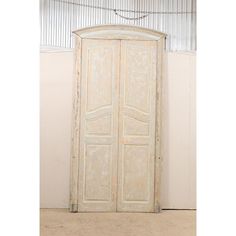 an old white wooden door in the corner of a room