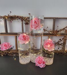 three vases with pink roses in them sitting on a table