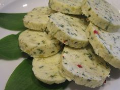 a white plate topped with cheese and green leaves