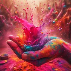 a person's hand is covered in colored powder and sprinkled with water