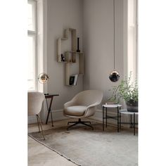 a living room with a chair, table and bookshelf on the wall next to a window