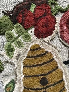 an embroidered table cloth with flowers and a beehive