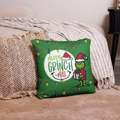 the grinch christmas pillow is sitting on a couch