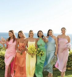 a group of women standing next to each other on top of a lush green field