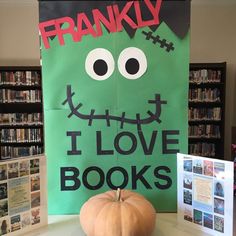 there is a green sign that says i love books and a pumpkin on the table