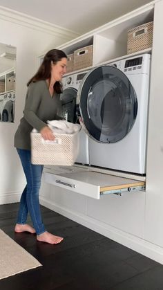 a woman holding a laundry basket in front of a washing machine with the door open