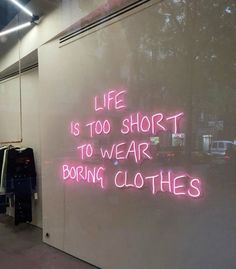 a neon sign that says life is too short to wear boring clothes on the wall