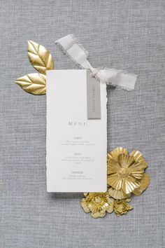 the wedding stationery was done with gold foil leaves, ribbon and a white menu card