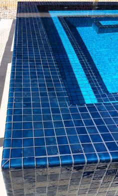 an empty swimming pool with blue tiled walls