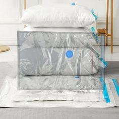 three pillows are stacked on top of each other and wrapped in plastic bags with blue handles