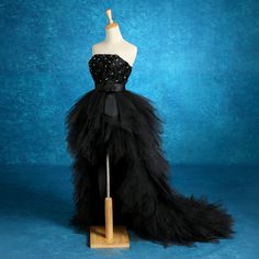 a mannequin wearing a black dress with sequins on the bustle