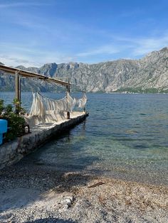 there is a hammock tied to the dock by the water's edge