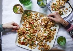 two people are cutting up food on a table