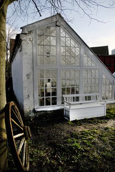 an old house with a white bench in front of it