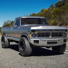 an old truck is parked on the side of the road