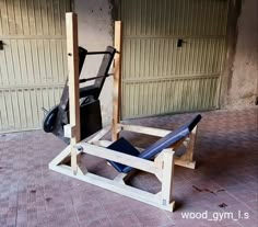 a wooden bench sitting in front of two garage doors next to a black bag on top of it