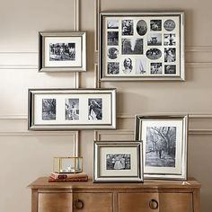 several framed pictures on a wall above a dresser