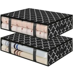 two black and white boxes stacked on top of each other with sheets folded in them