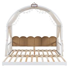 a white bed with wooden slats and string lights