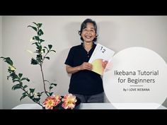 a man standing next to a vase with flowers and a sign that says ikebana tutorial for beginners