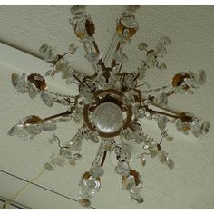 a crystal chandelier hanging from the ceiling in a room with white walls and ceilings