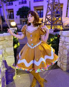 a woman dressed in a gingerbread costume posing for the camera with her hands on her hips