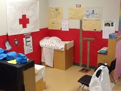 a hospital room with red cross on the wall and other medical supplies in boxes around it