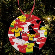 a christmas ornament hanging from a tree with soccer jerseys on it's side