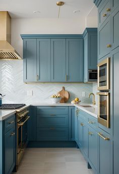 a kitchen with blue cabinets and gold accents