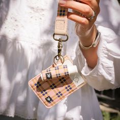 a woman is holding up her cell phone and keychain