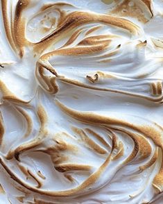 a close up view of a cake with white frosting and brown swirls on it