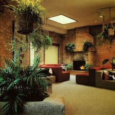 a living room filled with lots of furniture next to a fire place and potted plants