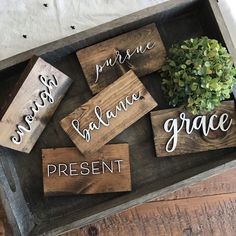 some wooden signs that are on top of a wood box with plants in it and the words grace, peace, balance, grace