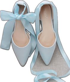 a pair of blue shoes with a bow on the side