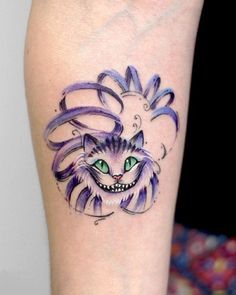 a cat with green eyes and purple hair on the left arm is depicted in this tattoo design