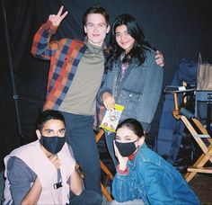 three people posing for the camera wearing face masks