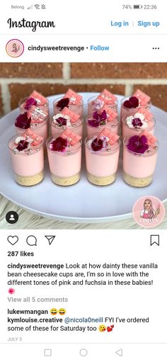 some small desserts are sitting on a plate with pink frosting and red flowers