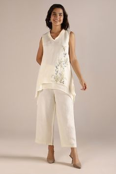 Off white asymmetric hem top with scattered floral hand embroidery and geometric gold
circles heat-pressed on the fabric. Paired with a coordinating pant. - Aza Fashions Honey Suckle, Off White Pants, Asymmetrical Hem Top, Kurti Patterns, Dress And Jacket Set, Asymmetric Top, Pant For Women, Cropped Pants Women, Scarf Knitting Patterns