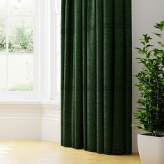 a green curtain in front of a window with a potted plant next to it