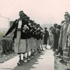 an old black and white photo of people rollerblading down a sidewalk with their feet in the air