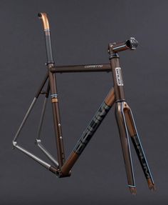 a bike frame with wood and metal parts on it's front end, against a gray background