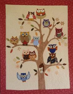 an owl themed wall hanging on the side of a tree with owls perched on it