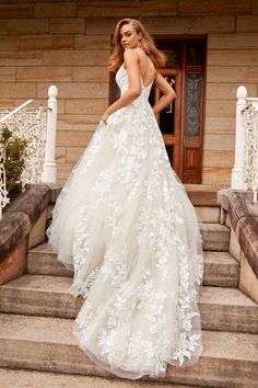 a woman in a wedding dress standing on steps