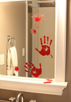 a bathroom mirror with red hand prints on it