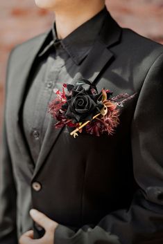 a man in a black suit with a flower on his lapel