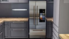 a metallic refrigerator freezer sitting inside of a kitchen next to wooden counter tops and gray cabinets