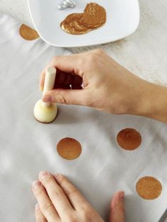 a person is peeling something off of a piece of paper on a table with polka dots