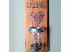 a mason jar is mounted on a wooden plaque that says pocket change with coins in it